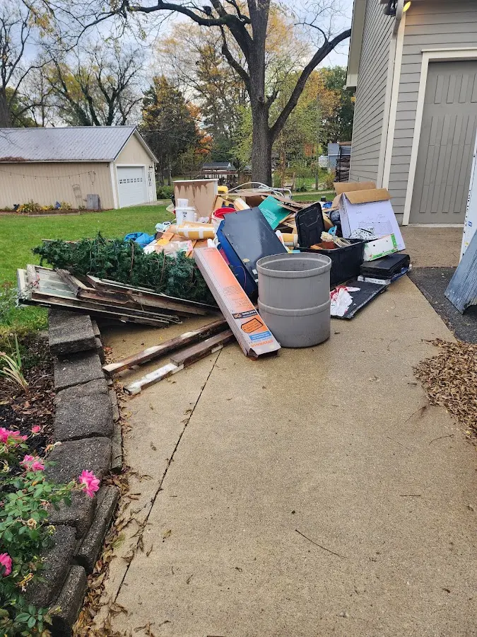 Dumpster being loaded with debris for Estate Cleanout Dumpster Rental in Wolverine Lake